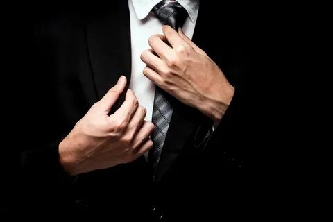 Мужчина поправляет галстук